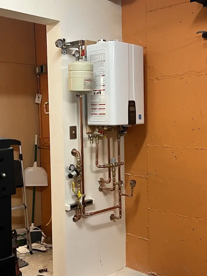 Plumbing technician inspecting water heater connections in Boulder Creek